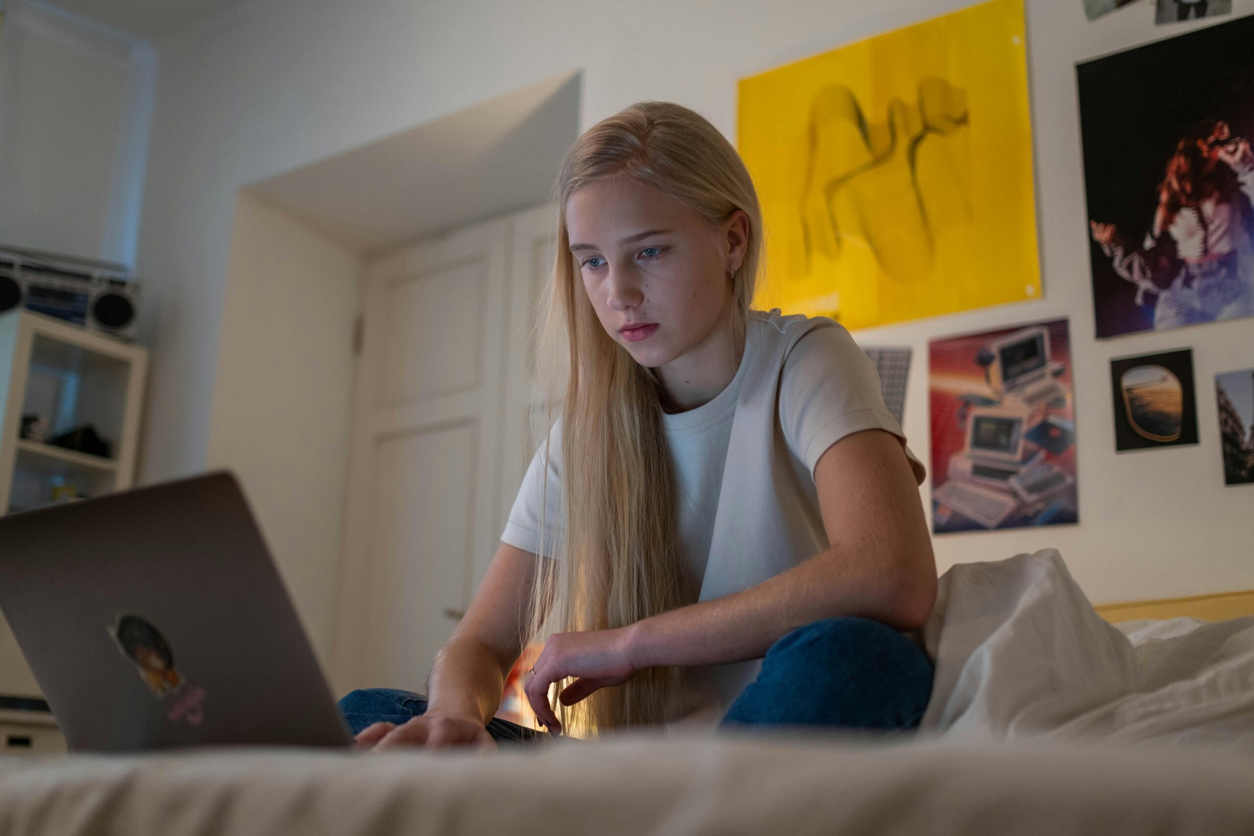 Young girl in her bedroom engaged in a virtual therapy session with a psychiatrist.